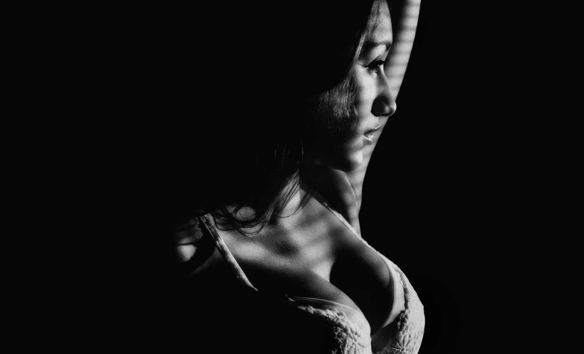 A black and white photo of a woman in lingerie, showcasing timeless allure.