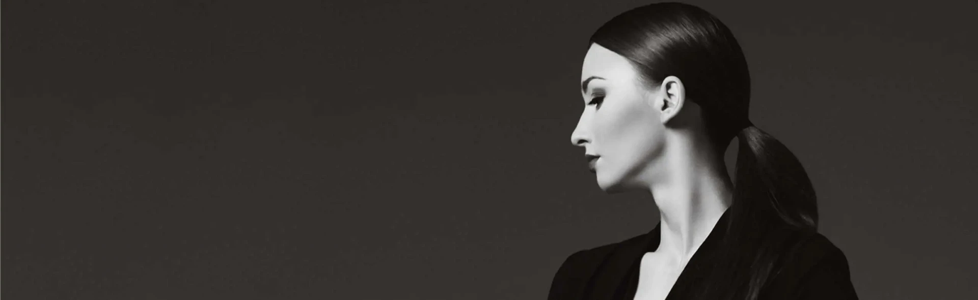 A black and white photo of a woman with a ponytail showcasing stunning facelift results.