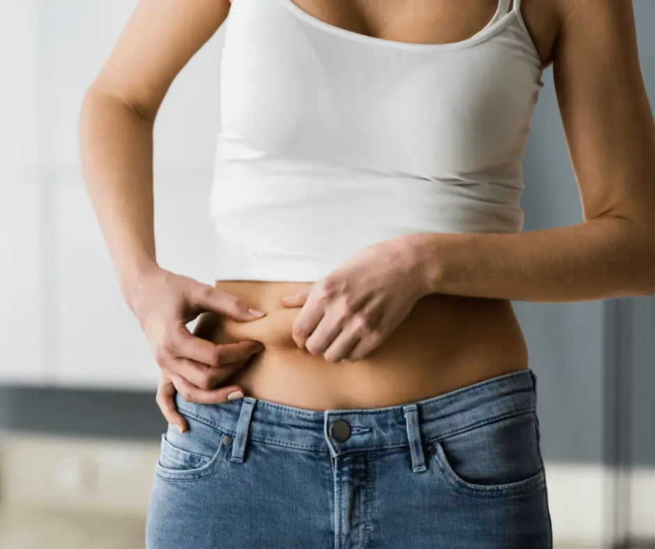 A woman is awake and putting her hand on her stomach.