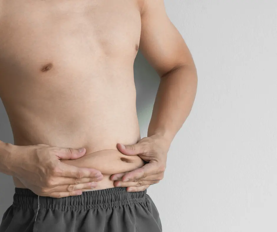 A man is holding his stomach with his hands after undergoing a Smartlipo procedure.