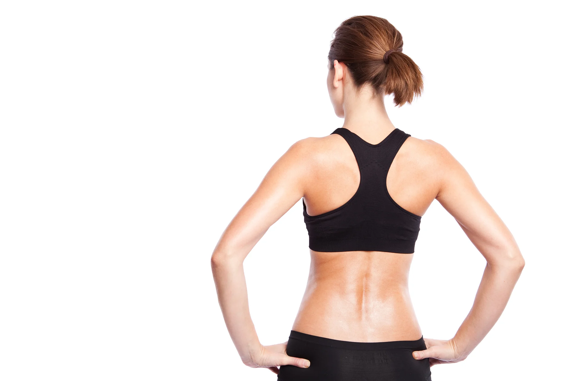 The sculpted upper back of a woman in a black sports bra.