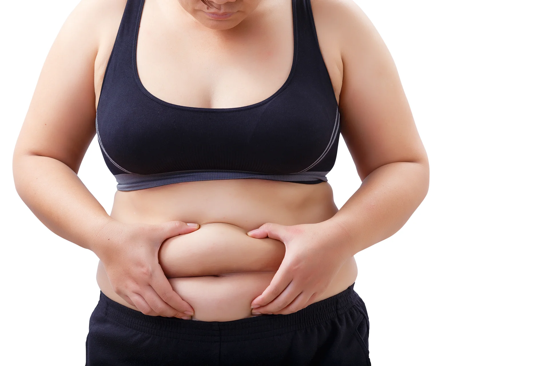 Woman pinching stomach fat, wearing a sports bra and workout pants, isolated on a white background. What You Need to Know about Lipo 360.