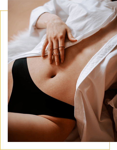 Person lying down, wearing a white shirt and black underwear, with one hand resting on their abdomen.