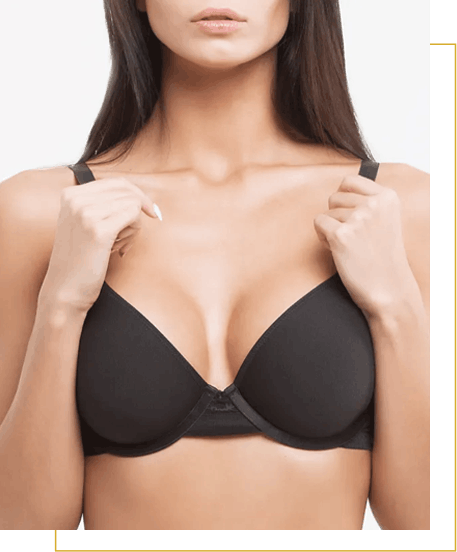 A woman wearing a black bra, holding the straps with both hands, shown from shoulders to mid-torso against a plain background.