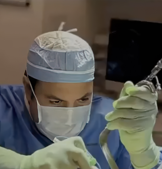 A medical professional from Our Practice, wearing surgical attire and gloves, is focused on handling surgical instruments in an operating room.