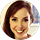 A woman with brown hair smiles at the camera in a close-up photo with a blurred background, perfect for showcasing customer testimonials.